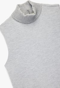 Top sin mangas de cuello alto en gris claro. Textura de cuello acanalada, forma ajustada y tejido de punto suave. Diseño minimalista, sin patrones ni acentos visibles.