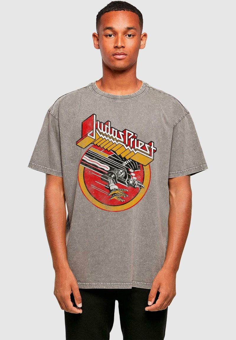 Graues, übergroßes T-Shirt mit einem auffälligen roten und gelben Grafikmotiv einer Hand und dem Text "Judas Priest", in einer weichen, abgenutzten Textur.