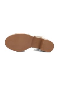 Tan sandaal met een gestructureerde bovenkant, dikke band en platte rubberen zool. De zool heeft een gladde afwerking met een lichte hak aan de achterkant.