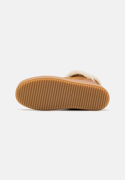 Brown suede boot with a soft white fur lining and a textured rubber sole featuring horizontal grooves for grip.