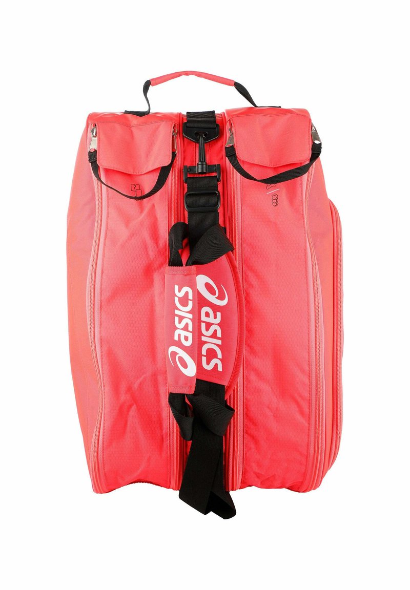 Sac de sport Asics rouge avec une sangle noire réglable, deux poches latérales zippées avec rabats et une poignée supérieure sur fond blanc.