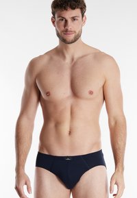 Marineblauwe herenonderbroeken van zachte stof, met een lage taille, elastische tailleband en minimale stikseldetails.