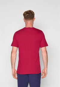 Rød bomulds T-shirt med korte �ærmer og rund halsudskæring, med en almindelig pasform og glat tekstur, vist fra ryggen.