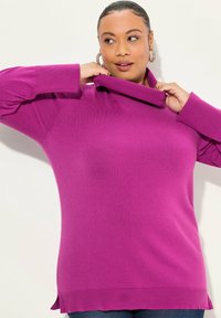 Maglione a collo alto fucsia realizzato in un morbido tessuto a maglia, con una vestibilità comoda e dettagli testurizzati sull'orlo e sui polsini.