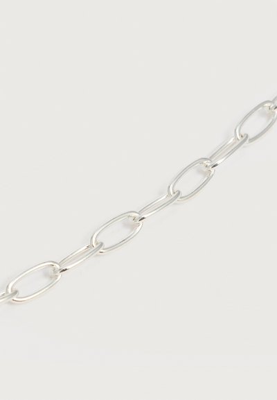 Ασημένια αλυσίδα με επιμηκυμένους οβάλ κρίκους σε ανοιχτό φόντο, που δείχνει κοντινή εικόνα από συνδεδεμένους μεταλλικούς κρίκους.