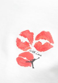 Τρία κόκκινα σημάδια κραγιόν πάνω από το κείμενο "Με Αγάπη" και μία μικρή μαύρη σιλουέτα ενός ατόμου που απλώνει το χέρι του προς τα πάνω σε λευκό ύφασμα.