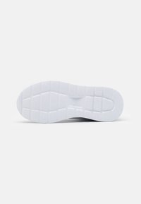Semelle de chaussure de sport blanche avec surface texturée, présentant des motifs rectangulaires et des rainures pour une adhérence et une flexibilité accrues.
