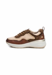 Zapatilla marrón y beige con materiales de ante y cuero texturizados, con una suela blanca, cordones en la parte frontal y mínimos acentos dorados.