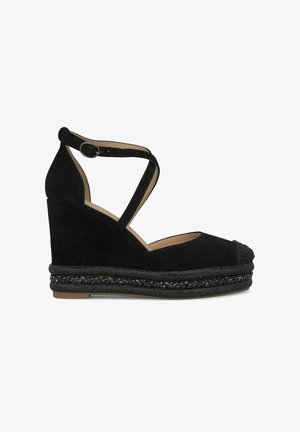 Zwarte suede wedge sandaal met kruisriempjes rond de enkel, geweven zwart materiaal aan de basis en gestructureerde teenkapdetails.