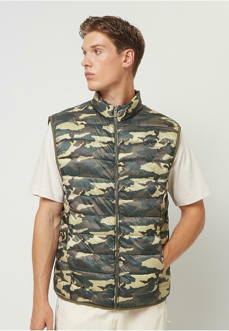 Weste mit Polsterung und camouflage Muster in Grüntönen und Brauntönen, mit hohem Kragen und durchgehendem Reißverschluss. Leichtes Material.