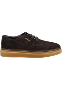Brown suede lace-up shoes with a round toe, contrasting gum sole, and stitching detail. Features a metallic logo on the side.
