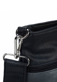 Lederhandtasche in dunkler Marinefarbe mit texturiertem Oberflächen, silbernem Beschlag, einem Reißverschlussöffnungs und einem abnehmbaren Tragegurt.