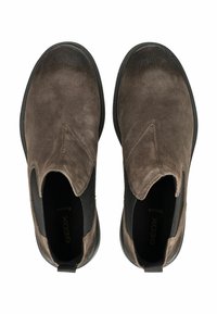 Par de botas Chelsea de ante marrón sin cordones, con paneles laterales elásticos negros y suelas de goma, vistas desde arriba.