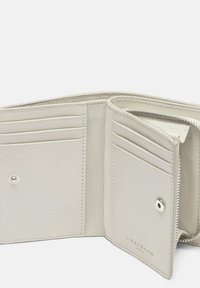 Billetera de cuero gris claro con múltiples ranuras para tarjetas, sección con cremallera y cierre a presión. Textura suave con bordes cosidos y marca.