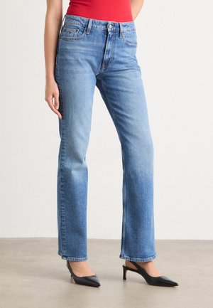 Light blue denim jeans with a straight leg design, featuring a classic five-pocket style and a mid-rise waist. Complemented by black heels.
