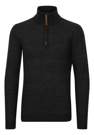 Svart stickad tröja med hög krage och kort dragkedjeslutning. Har ett texturerat mönster samt ribbade manschetter och fåll.