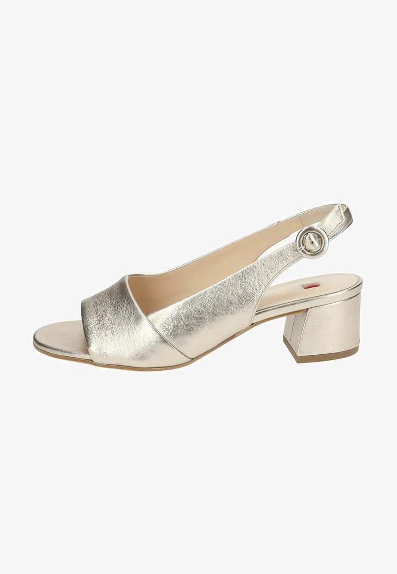 Metallisch goldene, offene Slingback-Sandale mit einem breiten Riemen, einem abgerundeten Blockabsatz und einem kreisförmigen Schnallen-Detail am Knöchelriemen.