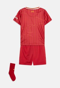 Camiseta atlética roja con un patrón geométrico amarillo, pantalones cortos a juego y calcetas rojas con un logo amarillo. Hecha de un tejido ligero.