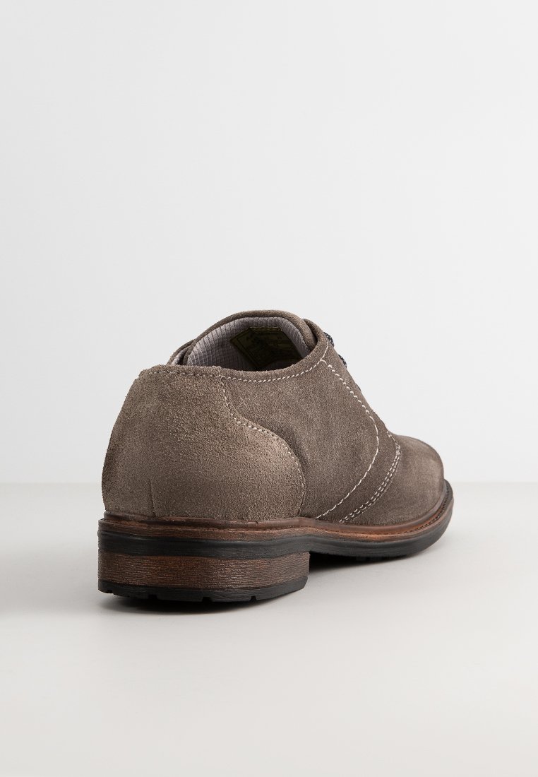 Zapato de ante marrón con un tacón redondeado, costuras en blanco en contraste y una suela texturizada. Diseño sencillo con un acabado suave y un perfil bajo.