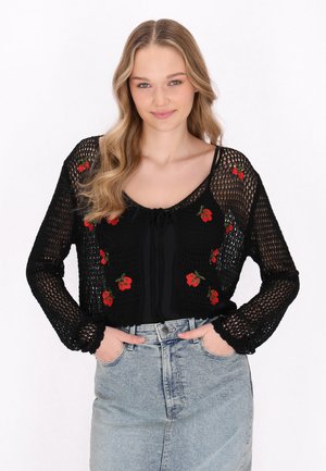 Zwart gebreid crop sweater met lange mouwen. Heeft rode bloemenborduurwerk op de voorkant. Geknoopte halslijn en gestructureerde stof. Spijkerrok.