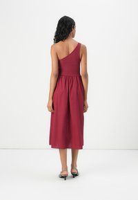 Robe midi bourgogne à une épaule avec un corsage ajusté et une jupe évasée. Fabriquée en tissu léger, elle offre une texture lisse et des lignes épurées.