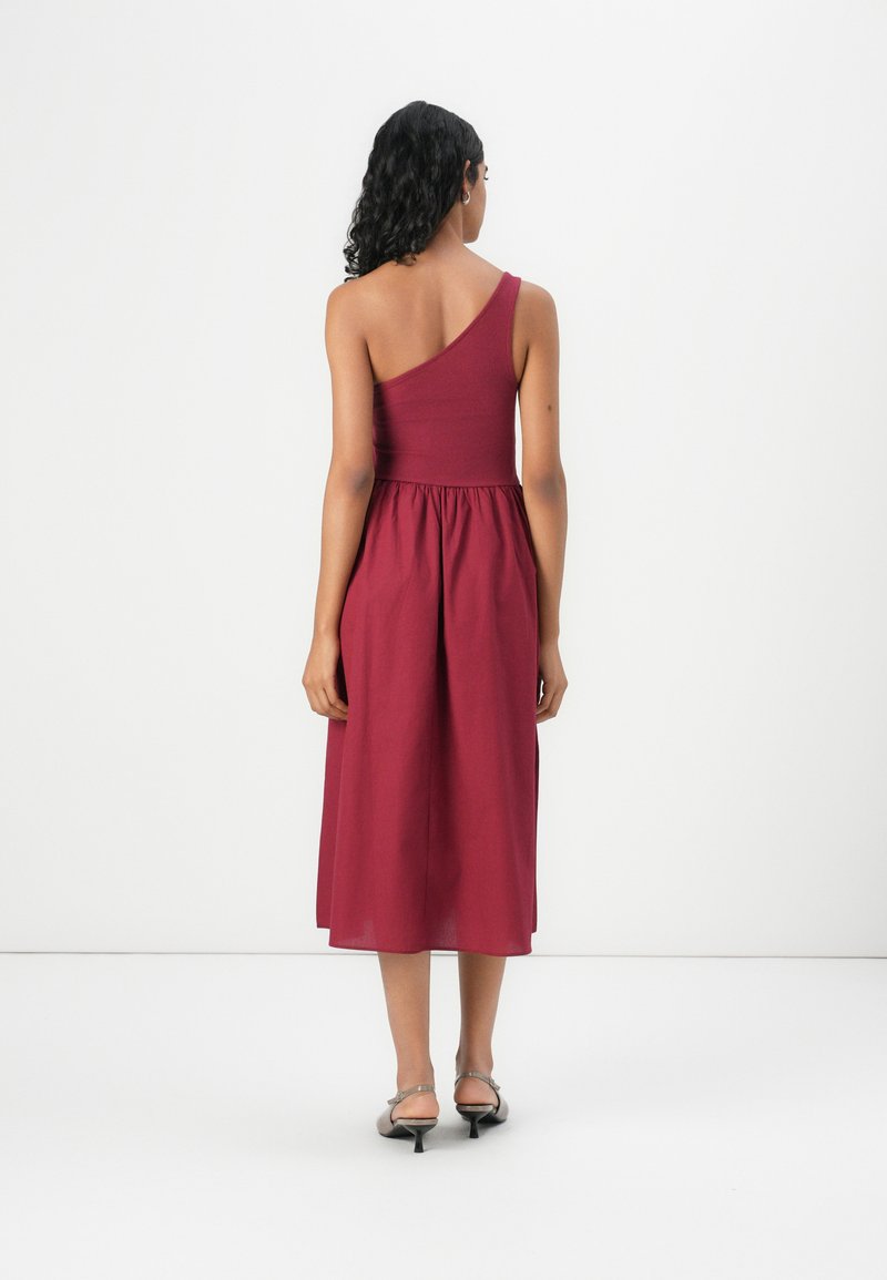 Robe midi bourgogne à une épaule avec un corsage ajusté et une jupe évasée. Fabriquée en tissu léger, elle offre une texture lisse et des lignes épurées.