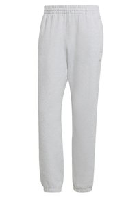 Vaaleanharmaat collegehousut, joissa on pehmeä pinta, joustava vyötärö ja kapenevat lahkeet. Sivulla on pieni logo.