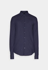Camisa de manga larga azul marino hecha de una tela suave, con un cierre de botones en la parte delantera y un logo sutil en el pecho. Dobladillo y puños redondeados.