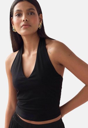 Black halter-top with a deep V-neck and fitted design. Smooth texture, complemented by large gold earrings and intricate tattoos on the arm.