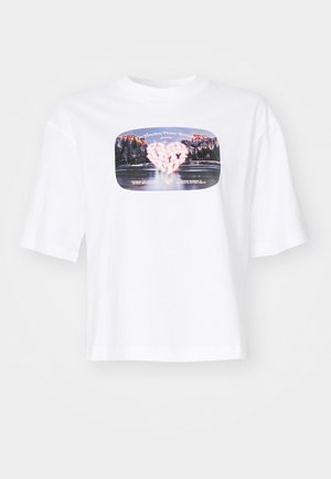 Valge puuvillane T-särk lõdva istuvusega. Omab värvikat trükitud graafikat, mis meenutab südamet ja kaunist maastikku ruudu kujulises raamis.