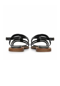 Zwarte leren sandalen met kruislings gesneden banden, een lage houten zool en een gesp bij de enkel. Glad textuur met minimale details.