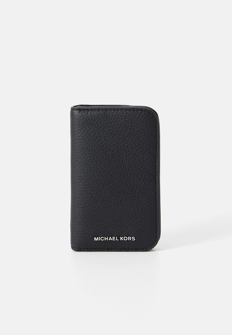 Svart lærpung med teksturert overflate, rektangulær form og hvit "MICHAEL KORS"-logo nederst.Minimalistisk design.