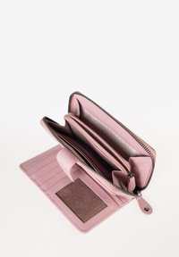 Portafoglio in pelle rosa con chiusura zip, dotato di più scomparti, slot per carte e una patch testurizzata per l'ID. Interno foderato in un colore chiaro.
