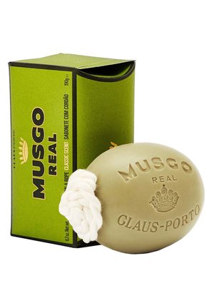 Green box with open top contains a round, light green soap with a white string loop, embossed with "MUSGO REAL GLAUS-PORTO."