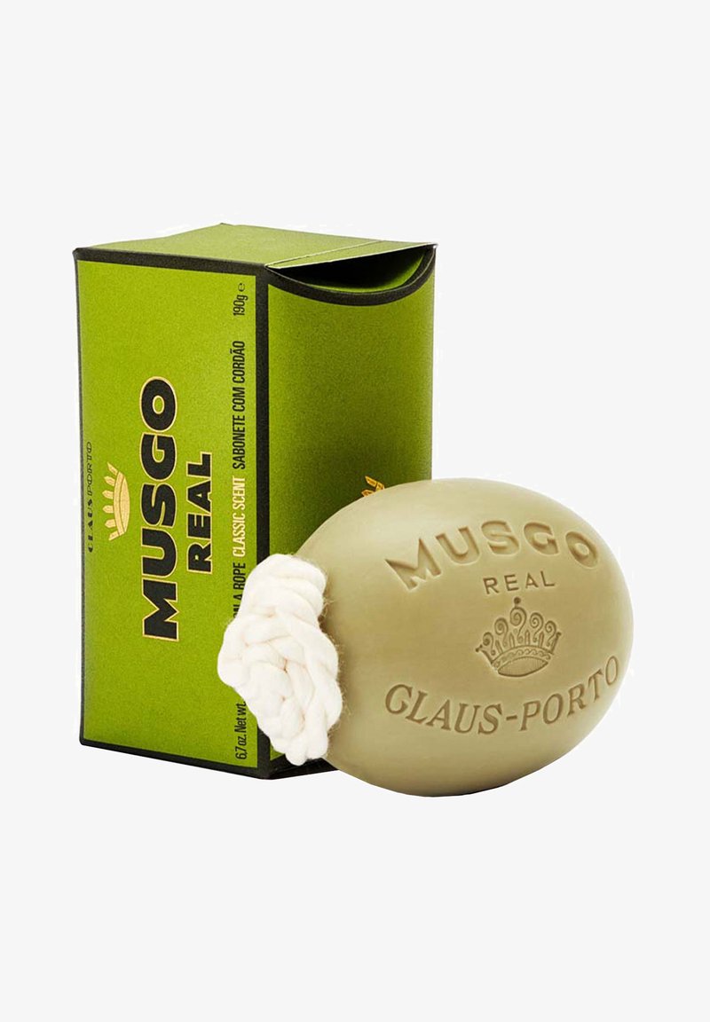 Groene doos met een open bovenkant bevat een ronde, lichtgroene zeep met een witte koordlus, gegraveerd met "MUSGO REAL GLAUS-PORTO."