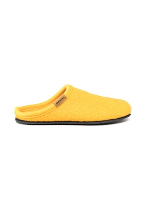 Chausson jaune à enfiler avec un tissu doux et texturé, semelle noire, et une petite étiquette marron sur le côté portant "Gottstein" sur fond blanc.