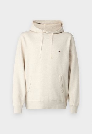 Beige bomullhette med justerbar hette, frontlomme, ribbestrikkede mansjetter, og en liten logo på brystet. Glatt tekstur.