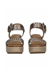 Sandali in bronzo metallico intrecciato con punta arrotondata, suola con piattaforma e dettaglio floreale sulla fascia. Sottopiede in pelle liscia e tacco resistente.