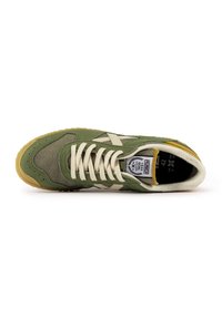 Scarpa atletica verde realizzata in tessuto e camoscio, con un logo bianco, lacci beige e una suola in gomma texturizzata. La vista dall'alto mette in evidenza i dettagli del design.