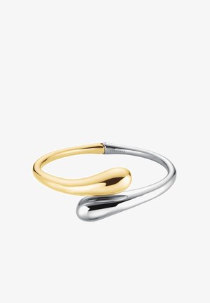 Zweifarbiges Armreifarmband mit einem glatten, geschwungenen Design und glänzenden gold- und silberfarbenen Metalloberflächen, das eine minimalistische Ästhetik zeigt.