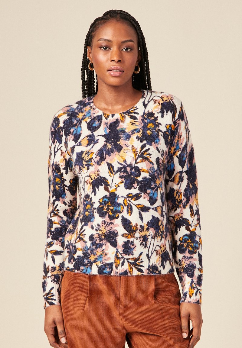 Maglione lavorato a maglia con motivi floreali, caratterizzato da un collo rotondo, maniche lunghe e fantasie multicolori in blu, giallo e rosa su uno sfondo bianco.