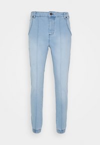 Pantalones jogger de mezclilla azul claro con puños elásticos, cintura alta y bolsillos frontales. Presenta detalles de costura vertical en toda su extensión.