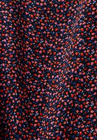 Tissu fleuri avec de petites fleurs rouges, roses et bleues sur fond noir ; texture douce avec un motif dense.