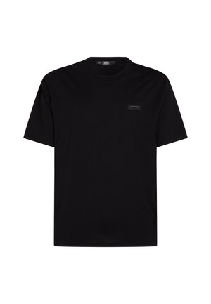 Camiseta negra de manga corta hecha de algodón, con cuello redondo y una pequeña etiqueta de la marca en el lado izquierdo del pecho. Diseño simple.