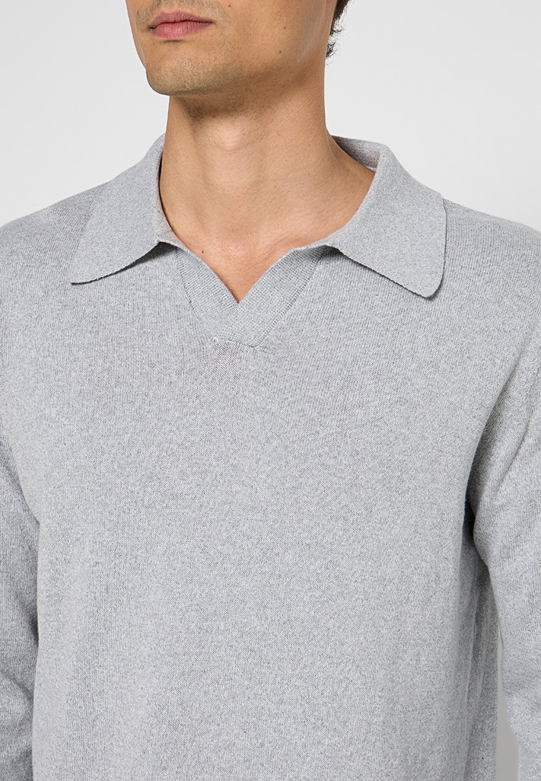 Pullover grigio chiaro in maglia con scollo a V e colletto. Texture morbida, design aderente e dettagli sottili sul colletto e sui polsini.