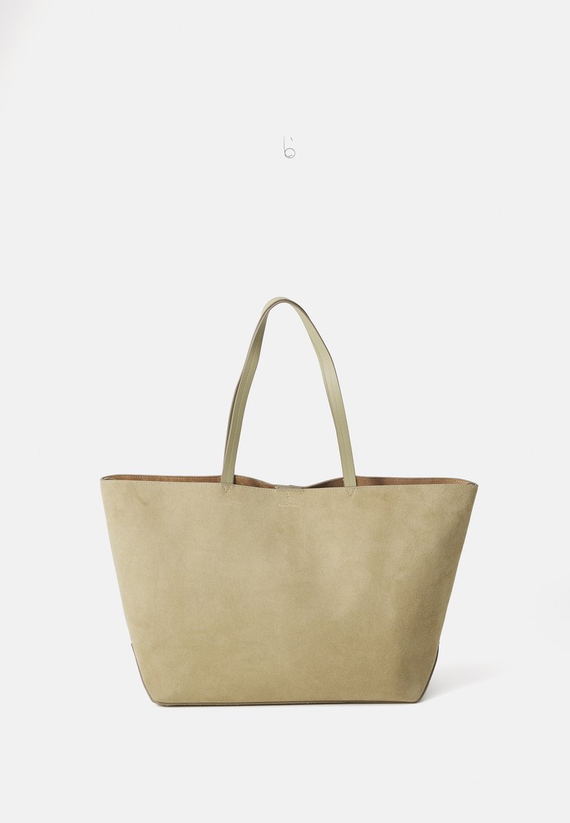Sac fourre-tout en suède beige avec deux poignées en cuir vert, de forme rectangulaire large et d'une surface légèrement texturée. L'intérieur présente une finition lisse.