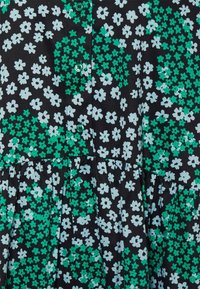 Musta kangasmekko, jossa on vihreä ja vaaleansininen kukkakuosisarja, napit edessä ja pussitettu vyötärö.