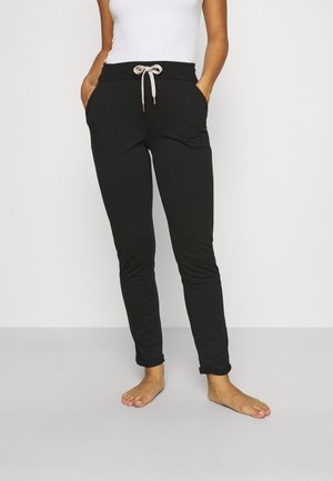 Schwarze Jogginghose mit elastischem Bund, Kordelzugverschluss, Seitentaschen und schlankem Schnitt. Der Stoff ist weich und dehnbar.