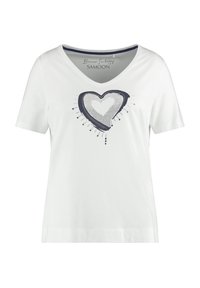 Weißes Baumwoll-T-Shirt mit kurzen Ärmeln und V-Ausschnitt, mit einem marineblauen Herzdruck, der gepunktete Details und nach unten gerichtete Akzente aufweist.