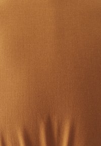 Texturovaná látka v teplém oranžovém odstínu, s hladkým povrchem a jemným leskem, se soft plicemi směrem dolů.